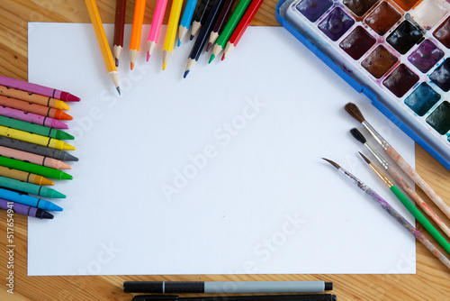 Colorful drawing supplies frame on white sheet free space, flat lay. Art, workshop, painting, inspiration, craft, creativity concept. Space for text. photo