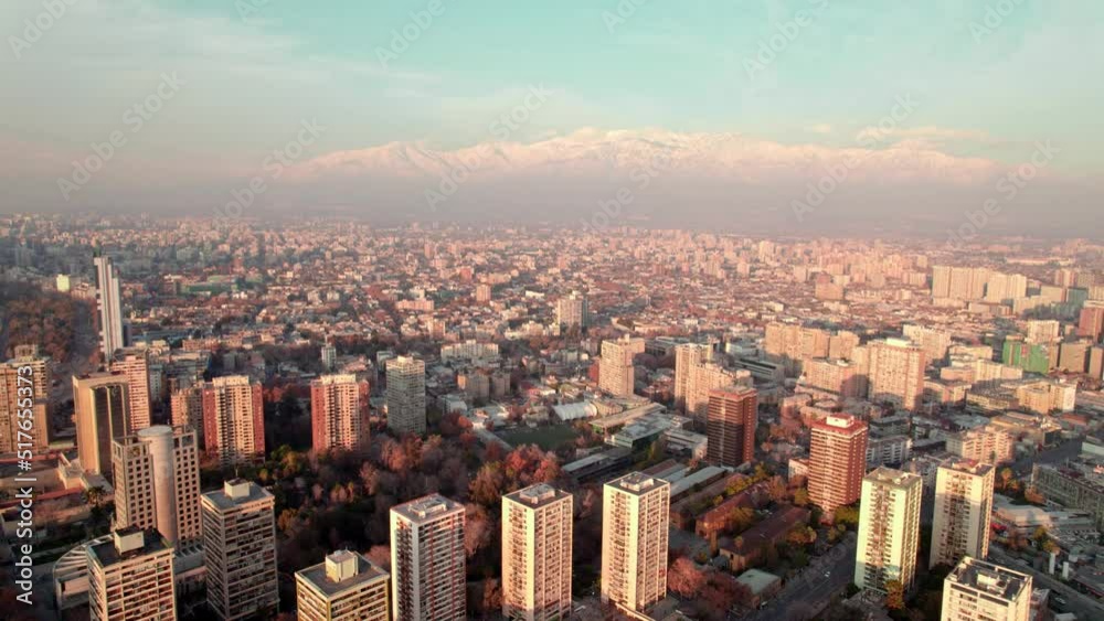 Aerial dolly in of Downtown Santiago city buildigns and snowcapped Andean mountain range in the background at sunset, Chile Aerial dolly in of Downtown Santiago city buildigns and snowcapped Andean mountain range in the background at sunset, Chile