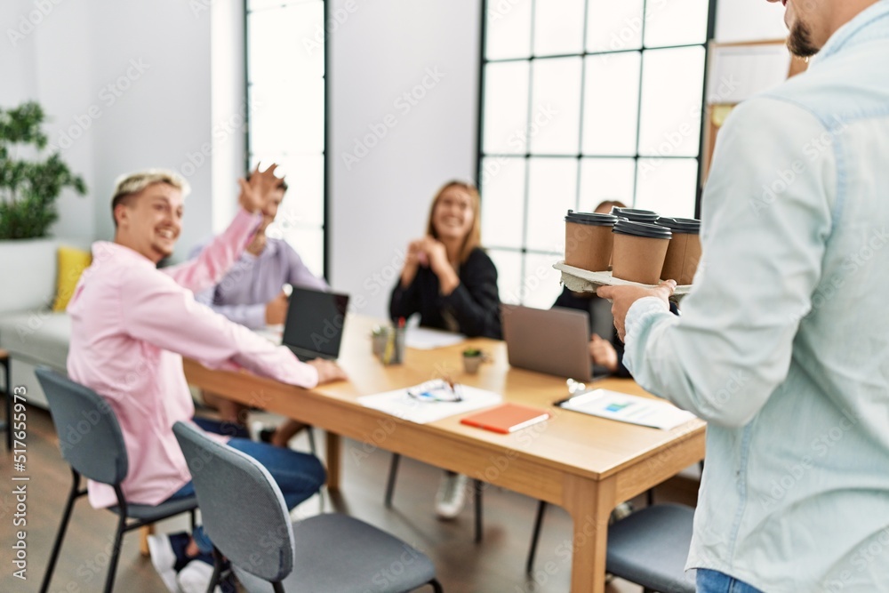 Group of business workers smiling happy working at the office. Partner man holding tray with take away coffee. Group of business workers smiling happy working at the office. Partner man holding tray with take away coffee.