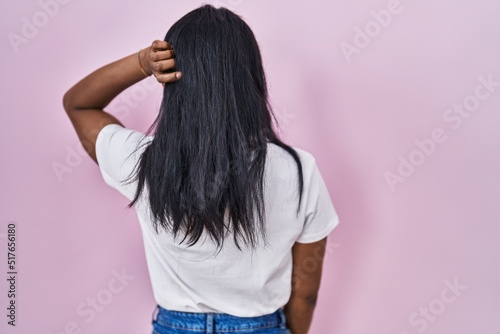 African young woman wearing casual white t shirt backwards thinking about doubt with hand on head