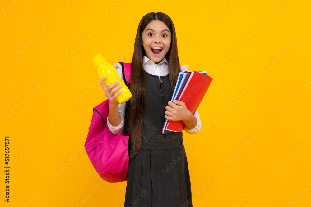 Amazed teen schoolgirl. Teenager school girl with backpack holding water bottle isolated on yellow background. Back to school concept. Healthy child. Excited expression, cheerful and glad. Amazed teen schoolgirl. Teenager school girl with backpack holding water bottle isolated on yellow background. Back to school concept. Healthy child. Excited expression, cheerful and glad.