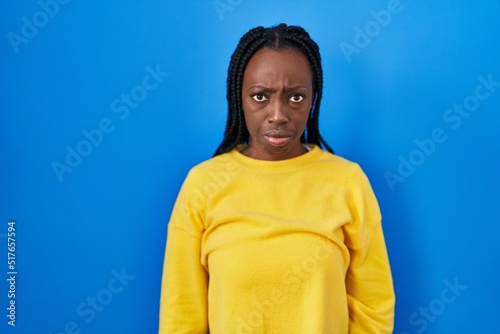 Beautiful black woman standing over blue background depressed and worry for distress, crying angry and afraid. sad expression. © Krakenimages.com