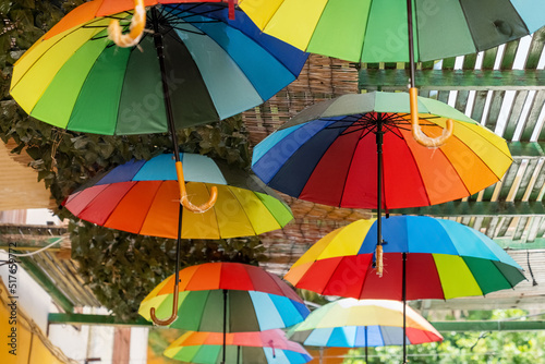 Rainbow colourful umbrellas decoration in outside cafe bar, old town street of Crete island, Greece. Travel vacation concept.