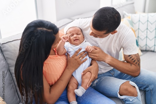 Hispanic family smiling confident sitting on sofa at home