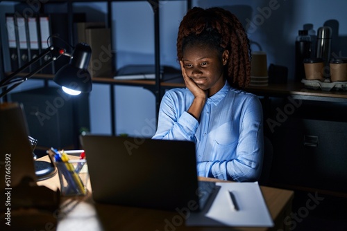 African woman working at the office at night thinking looking tired and bored with depression problems with crossed arms.