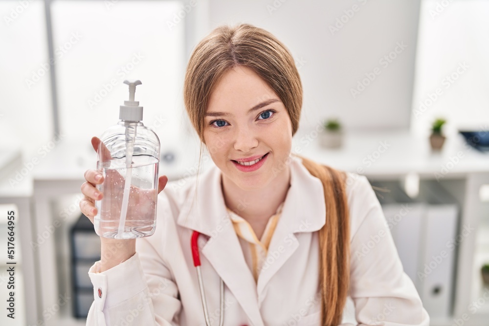 Young blonde woman wearing doctor uniform holding sanitizer gel hands at clinic Young blonde woman wearing doctor uniform holding sanitizer gel hands at clinic