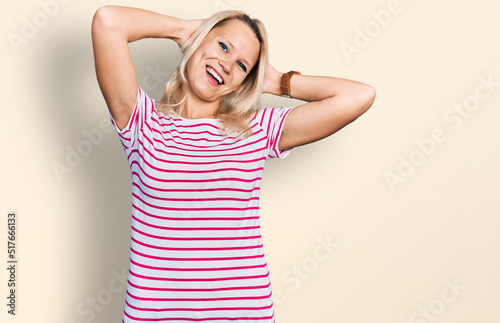 Young caucasian woman wearing casual clothes relaxing and stretching, arms and hands behind head and neck smiling happy