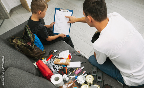 Father and son assemble the emergency evacuation bag together and put necessary items into backpacks