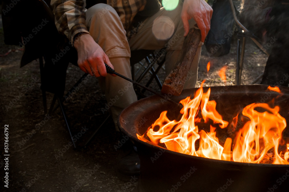 Campfire burning in a firepit . People sitting around. Camping life. Outdoor recreation. Campfire burning in a firepit . People sitting around. Camping life. Outdoor recreation.
