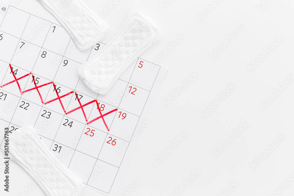 Calendar with red marks and white pad. Menstruation period concept Calendar with red marks and white pad. Menstruation period concept