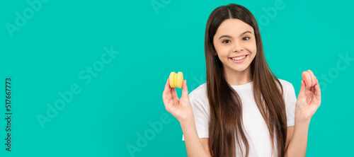 happy teen girl hold french macaron or macaroon cookies, confectionary. Teenager child with sweets, poster banner header, copy space. photo