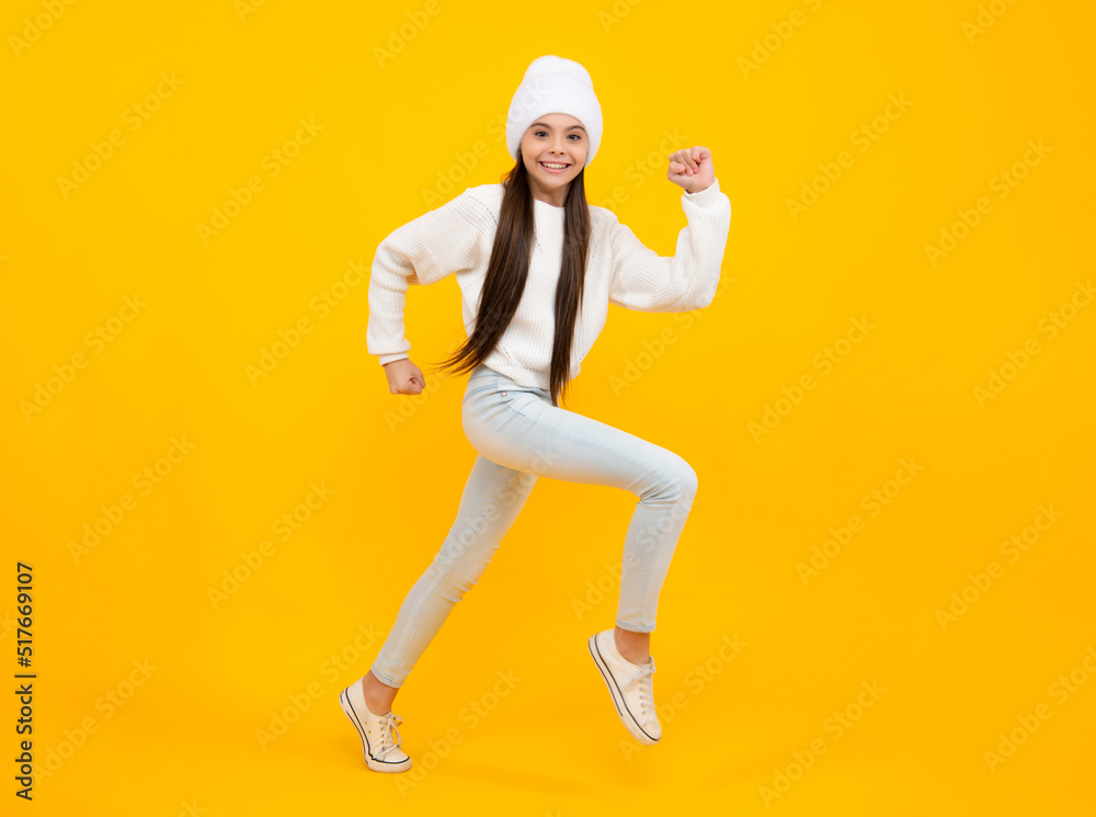 Happiness, freedom, motion and child. Young teenager girl jumping over yellow background, funny jump.