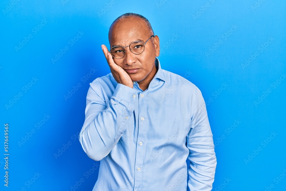 Middle age latin man wearing casual clothes and glasses thinking looking tired and bored with depression problems with crossed arms. Middle age latin man wearing casual clothes and glasses thinking looking tired and bored with depression problems with crossed arms.