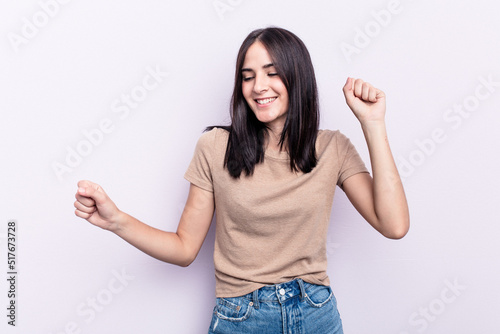 Young caucasian woman isolated on pink background dancing and having fun.