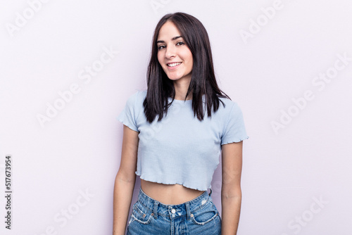 Young caucasian woman isolated on pink background confident keeping hands on hips. © Asier