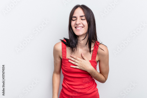 Young caucasian woman isolated on white background laughs out loudly keeping hand on chest.