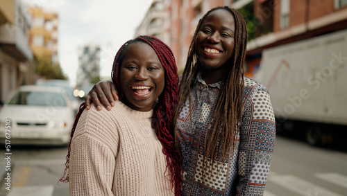 Two african american friends smiling confident hugging each other standing at street