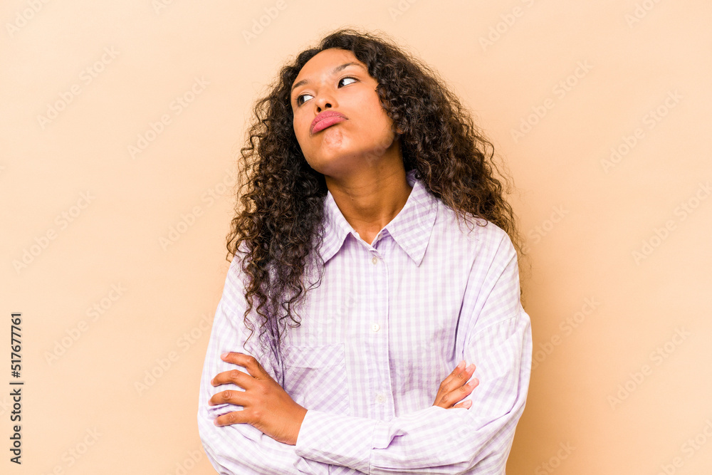 Obraz premium Young hispanic woman isolated on beige background tired of a repetitive task.
