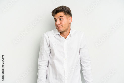 Young caucasian man isolated on white background shrugs shoulders and open eyes confused. © Asier