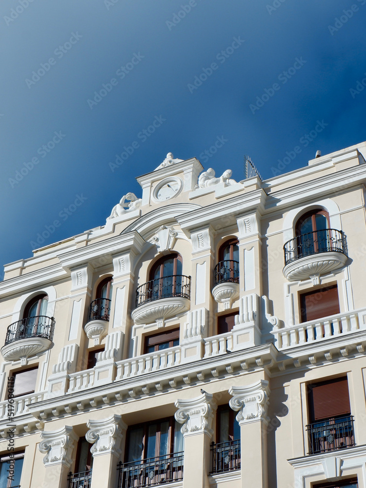 Beige classical facade of building in central district downtown Madrid, Spain. Vertical photo
