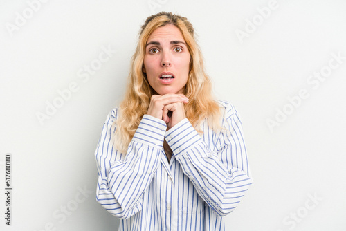 Young caucasian woman isolated on white background praying for luck, amazed and opening mouth looking to front.