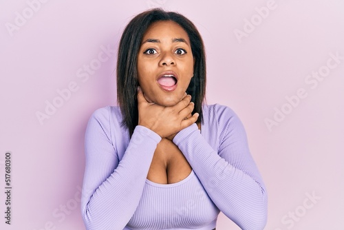 Young african american girl wearing casual clothes shouting and suffocate because painful strangle. health problem. asphyxiate and suicide concept.