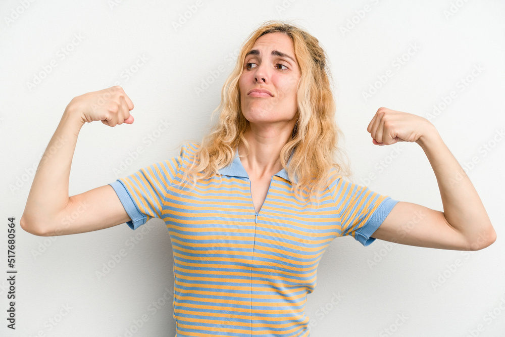 Young caucasian woman isolated on white background showing strength gesture with arms, symbol of feminine power Young caucasian woman isolated on white background showing strength gesture with arms, symbol of feminine power
