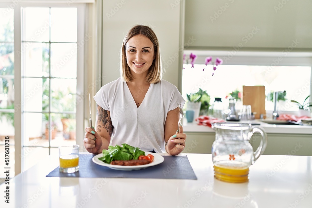 Young caucasian girl smiling happy having lunch at the kitchen. Young caucasian girl smiling happy having lunch at the kitchen.