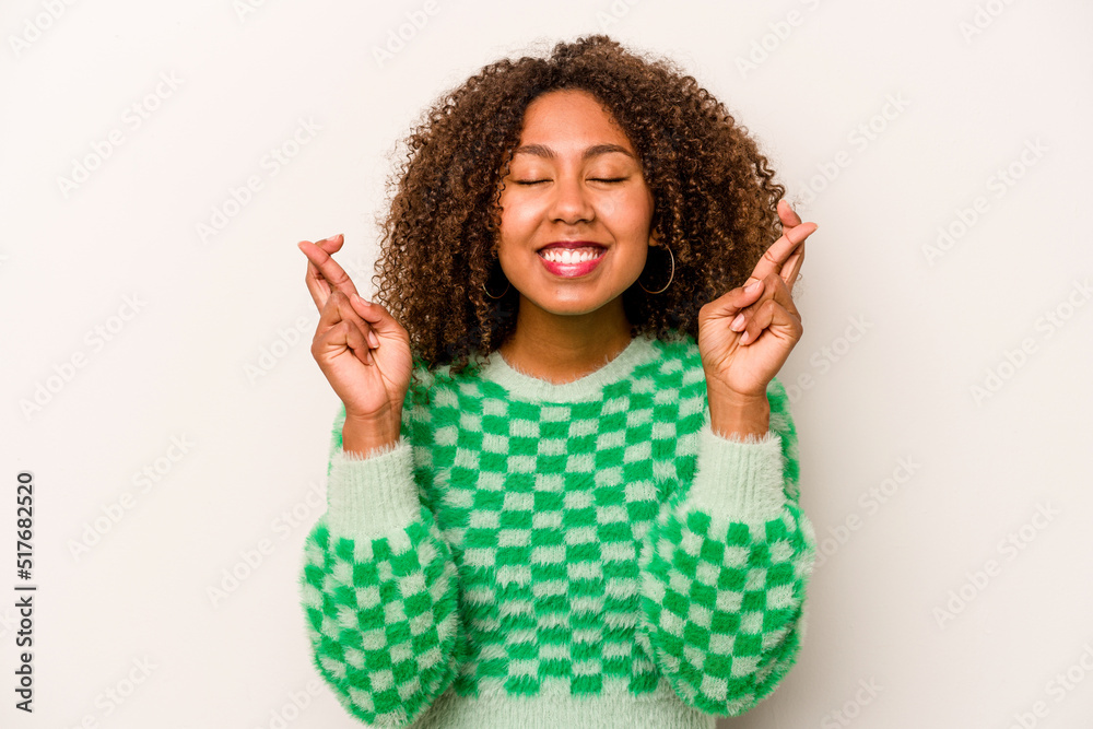 Young African American woman isolated on white background crossing fingers for having luck Young African American woman isolated on white background crossing fingers for having luck