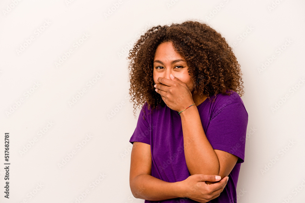 Young African American woman isolated on white background laughing happy, carefree, natural emotion.