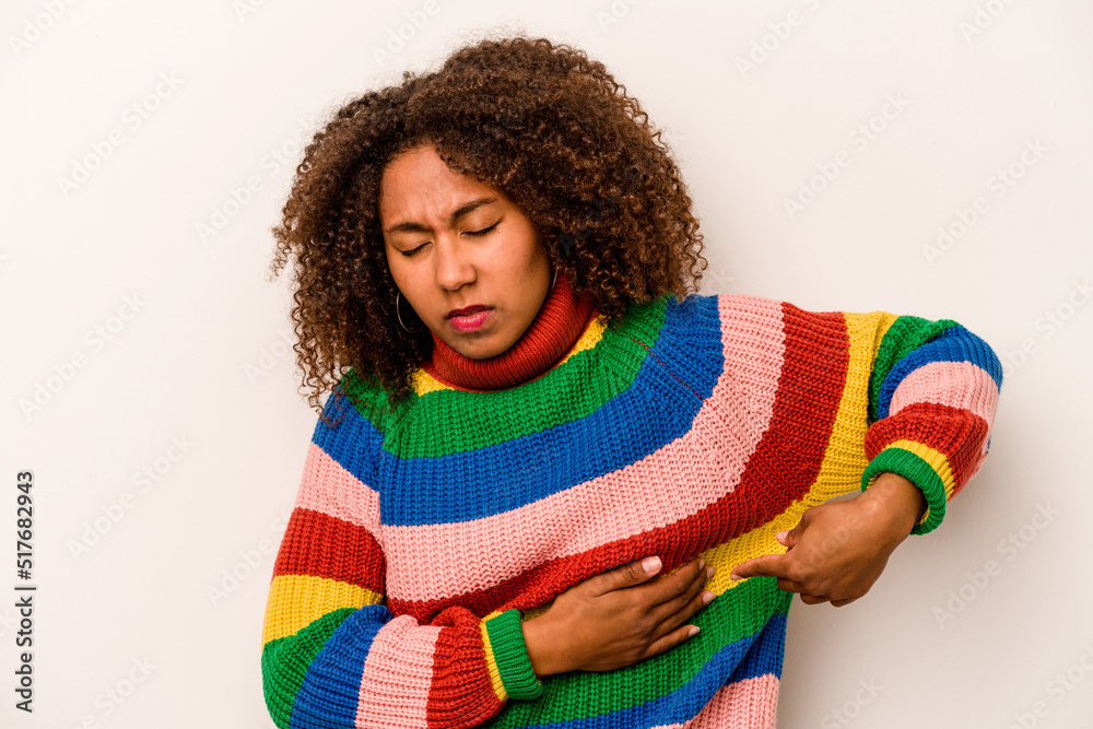 Young African American woman isolated on white background having a liver pain, stomach ache. Young African American woman isolated on white background having a liver pain, stomach ache.