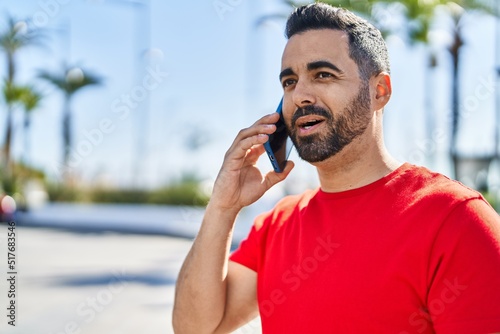 Young hispanic man smiling confident talking on the smartphone at street