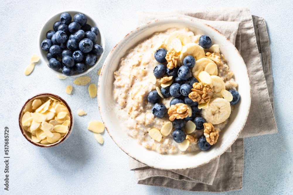 Oatmeal porrige in craft bowl at white background. Top view. Oatmeal porrige in craft bowl at white background. Top view.