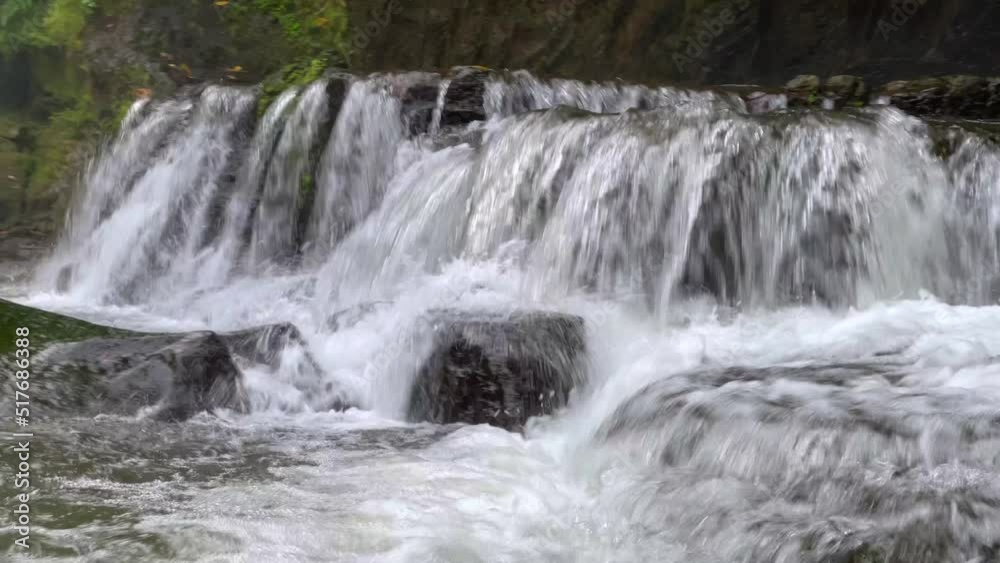 Close-up side view of cascading waterfall rapidly flowing down the rocks in the rainforest. Sumampan Waterfall in Ubud in Bali, Indonesia. 4K Video. Close-up side view of cascading waterfall rapidly flowing down the rocks in the rainforest. Sumampan Waterfall in Ubud in Bali, Indonesia. 4K Video.