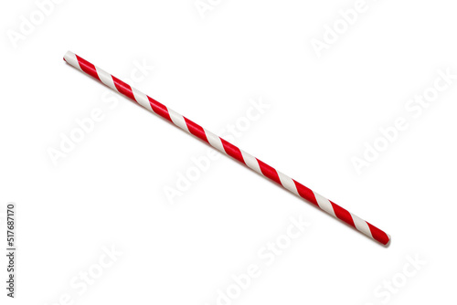 A red and white straw is placed diagonally on a white background. The concept of a children's holiday or party. A handy drinking accessory. Environmentally friendly product