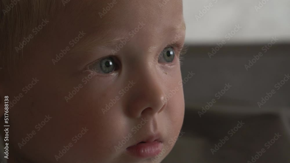 4k portrait of adorable young boy watching television at evening in the living room. Close-up face of child eyes while person using tablet, smartphone or computer. 4k portrait of adorable young boy watching television at evening in the living room. Close-up face of child eyes while person using tablet, smartphone or computer.
