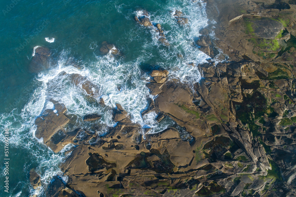 drone aerial view of a stretch of rocky coastline