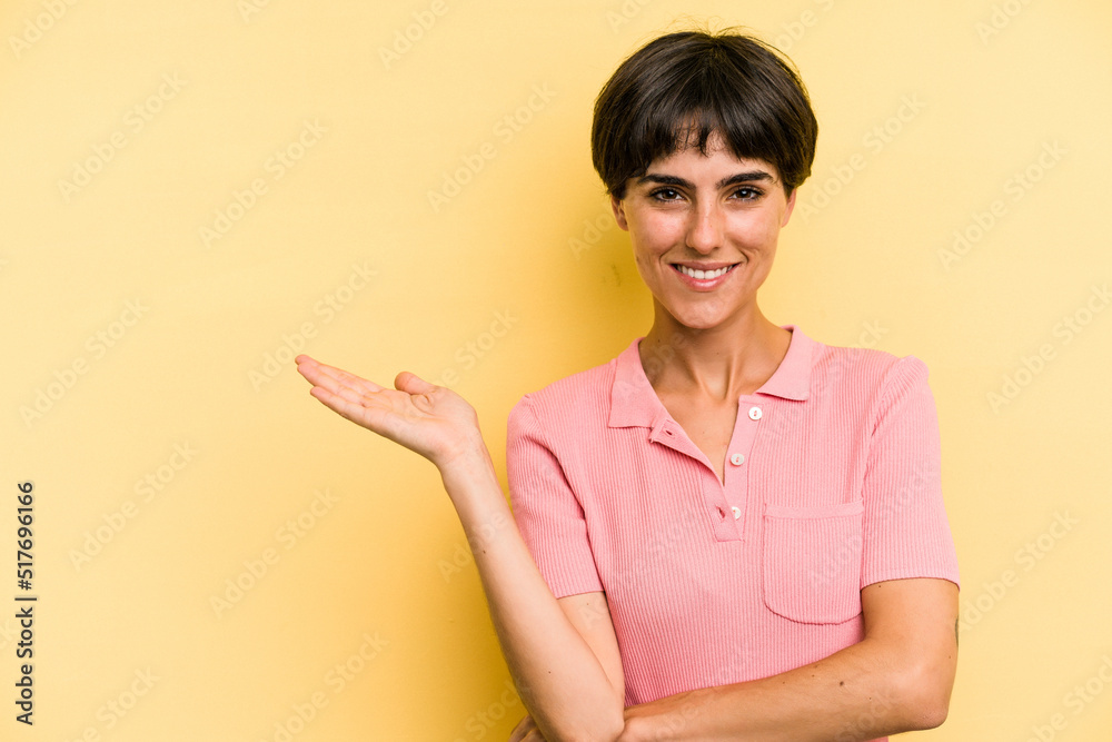 Young caucasian woman with a short hair cut isolated showing a copy space on a palm and holding another hand on waist. Young caucasian woman with a short hair cut isolated showing a copy space on a palm and holding another hand on waist.