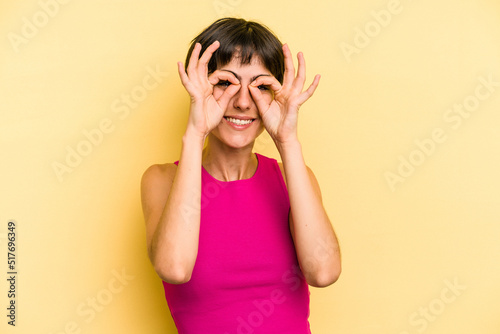 Young caucasian woman with a short hair cut isolated excited keeping ok gesture on eye.