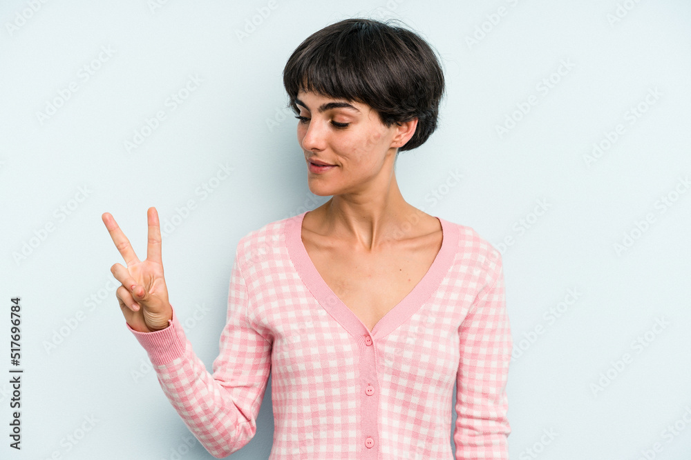 Young caucasian woman with a short hair cut isolated joyful and carefree showing a peace symbol with fingers. Young caucasian woman with a short hair cut isolated joyful and carefree showing a peace symbol with fingers.