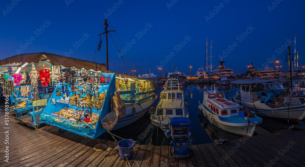 Night view with yachts and boats with souvenirs in port Mandraki marina, Rhodes, Greece