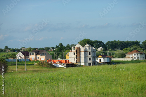 View of typical Ukrainian village. Households, building under construction, gardens and field. Klavdiivka, Kyiv oblast, Ukraine photo