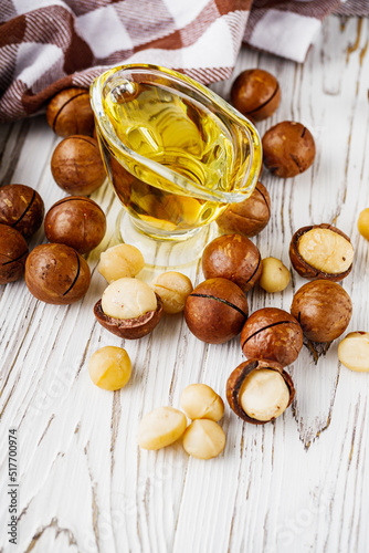 fresh macadamia nuts on a white wooden rustic background