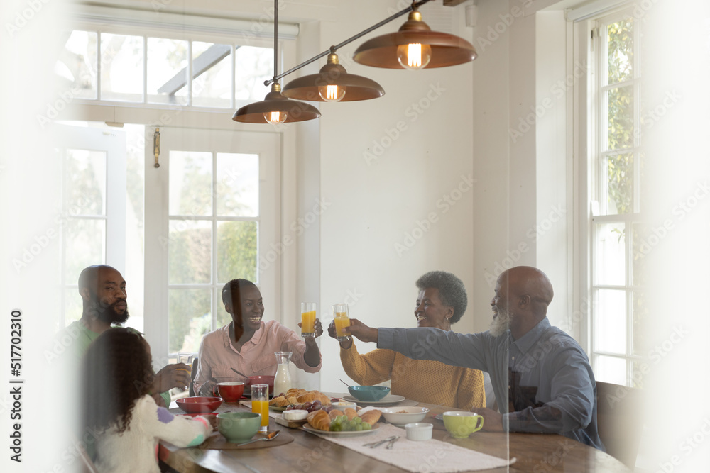 Image of happy multi generation african american family eating breakfast