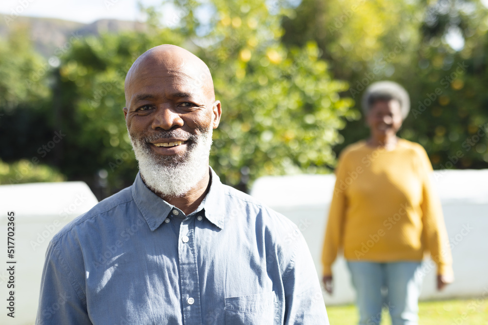 Image of happy african american senior man with wife in garden