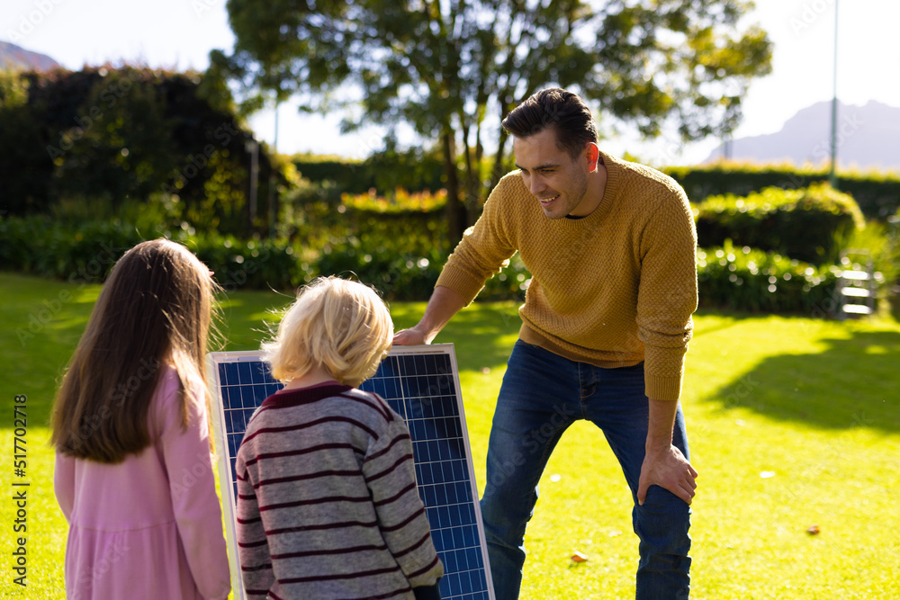 Image of caucasian father showing solar panel to children Image of caucasian father showing solar panel to children