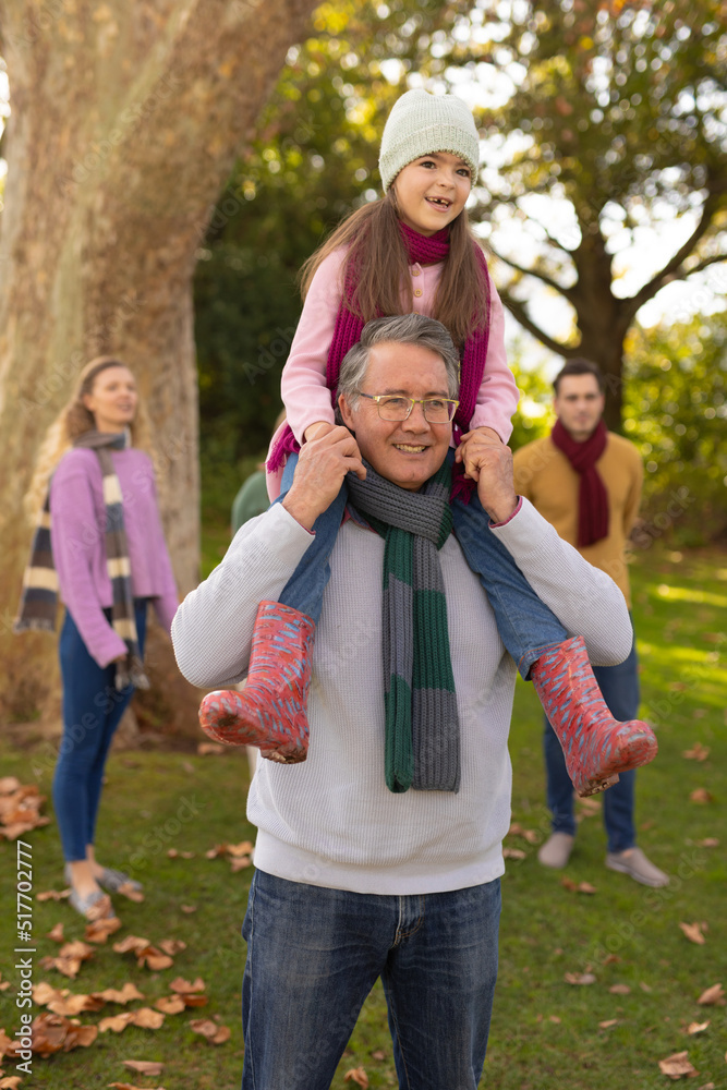 Vertical image of happy caucasian girl with grandfather in garden Vertical image of happy caucasian girl with grandfather in garden