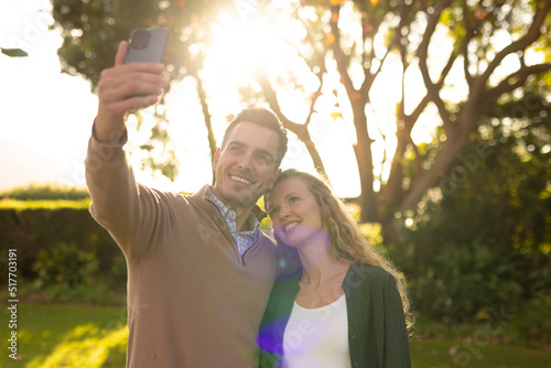 Image of happy caucasian couple taking selfie in garden © WavebreakMediaMicro