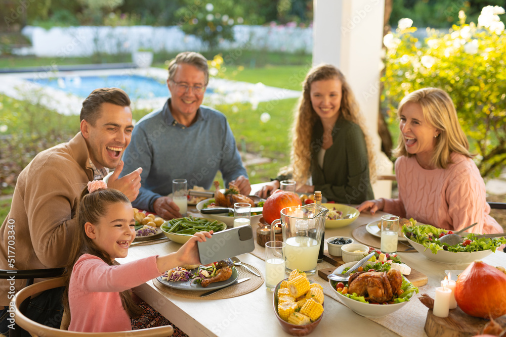 Image of multi generation caucasian family eating outdoor dinner