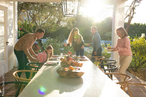 Image of multi generation caucasian family preparing outdoor dinner